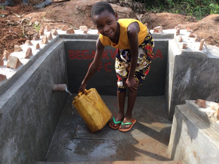 Child fetching water from the well after construction-min