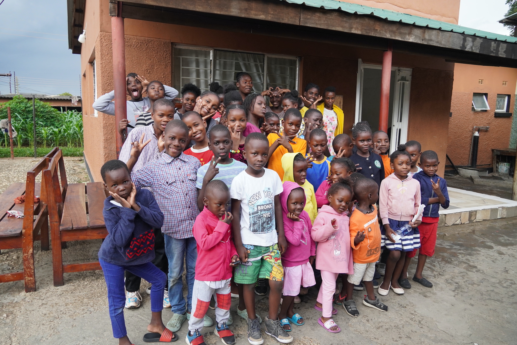 A group of of children stand outside the Kabwata Orphanage showcasing the importance of education programs in africa.
