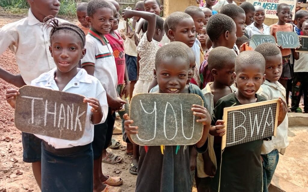 Students attending a school on the shore of Lake Tumba celebrate access to clean water
