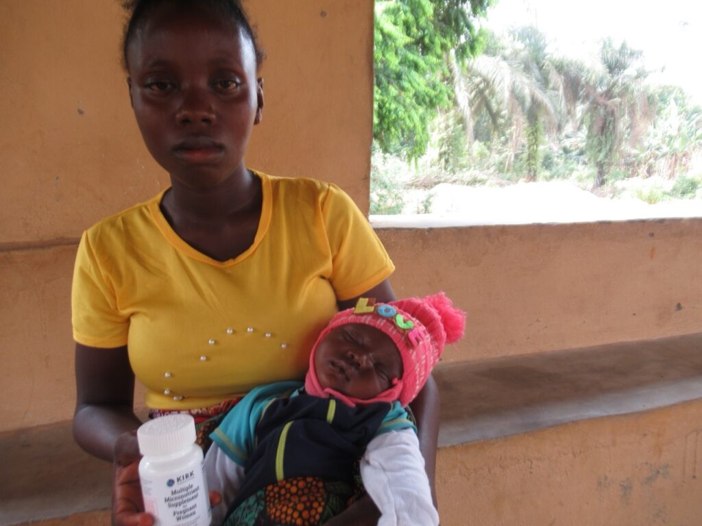 Rose Matta holds her healthy baby girl and a bottle of the micronutrient supplements that helped them both thrive.