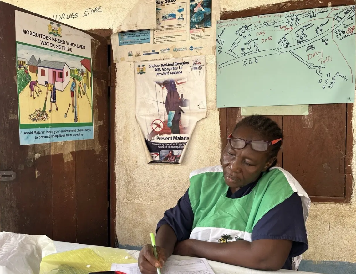 Community health worker documenting patient care in rural clinic.