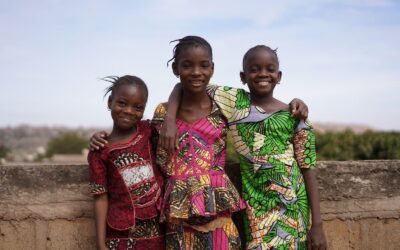 Three young African girls smiling & posing for picture
