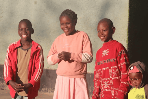 A group of happy, healthy children standing together at an orphanage in Africa.