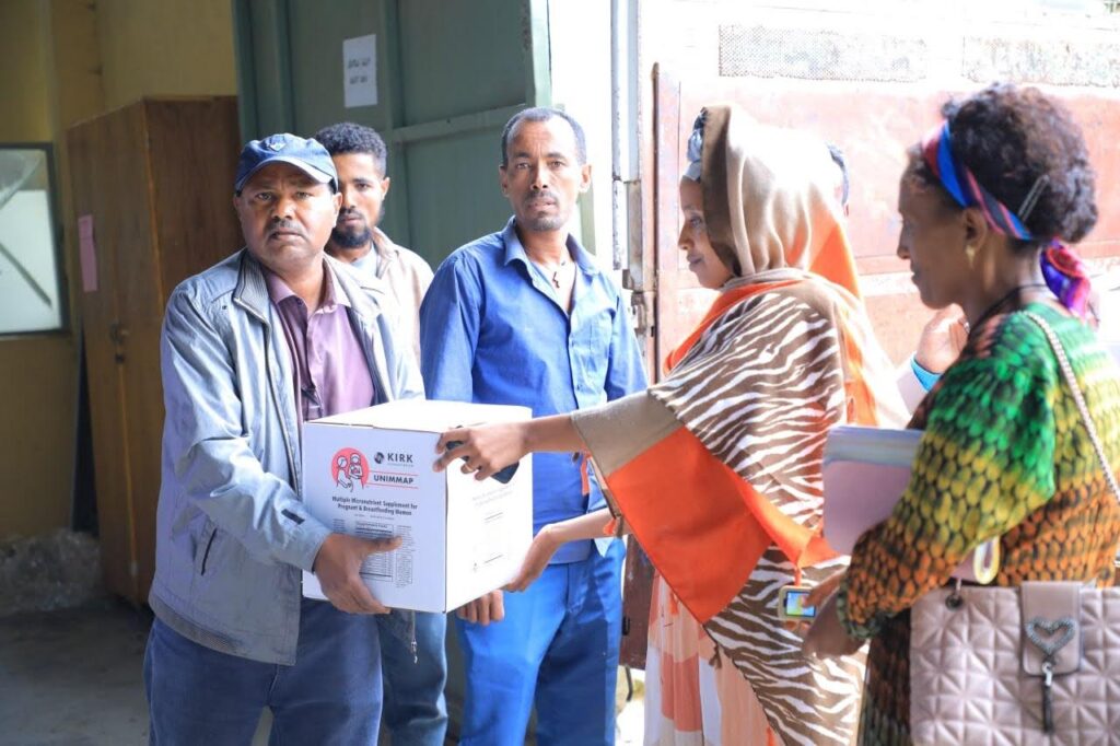 Volunteer distributing prenatal vitamins to the health center in Ethiopia.