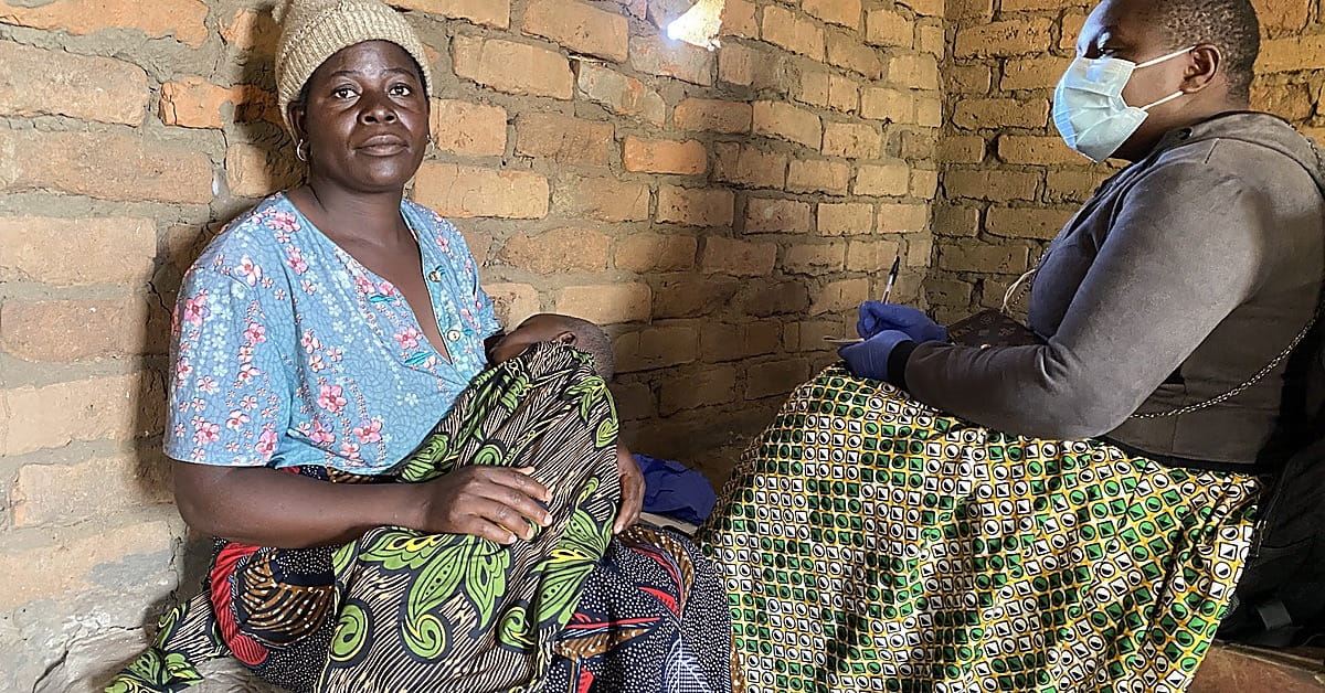 Mother holding her nine month old baby during a mobile clinic consultation in Jono Village, Malawi.